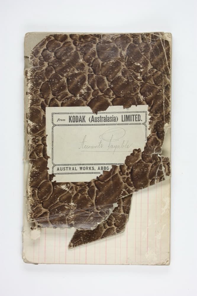 A worn early-20th-century accounts-payable ledger book